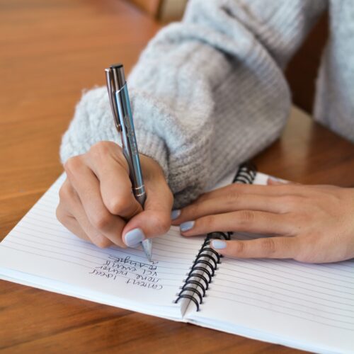 DSC_7100 a close up of a business owner writing a list of things to do in a notepad